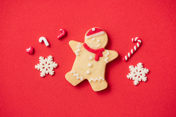 Top view of decorated Christmas gingerbread cookies on red table background with copy space, concept of holiday celebration. - Foto, Imagen
