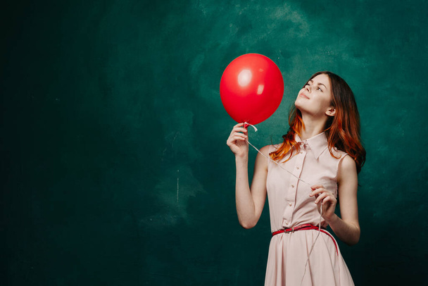 mujer alegre con globo rojo vacaciones de fondo verde - Foto, imagen