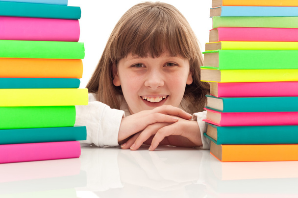 Girl between two piles of books - Фото, изображение