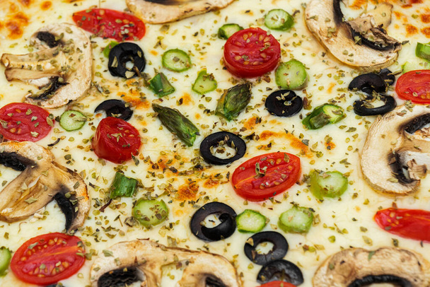 Primo piano della pizza vegetariana con funghi, formaggio, olive nere e pomodorini ciliegia. - Foto, immagini