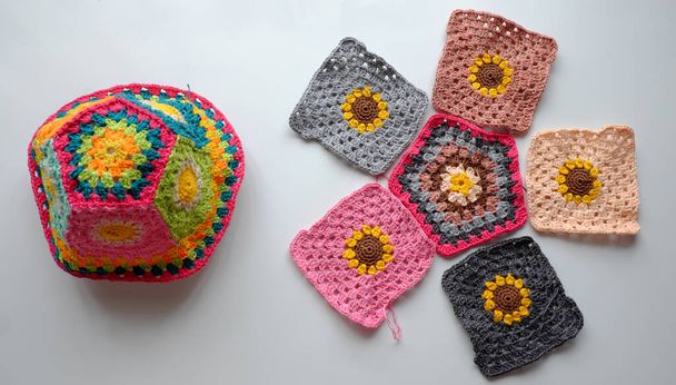 Top view handmade product to make spring present, colorful bucket hat with many piece link together, cute crochet hat from yarn on white background - Photo, Image