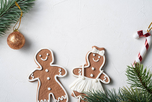 Top view of decorated Christmas gingerbread cookies with decorations on white table background with copy space, concept of holiday celebration. - Foto, Imagen