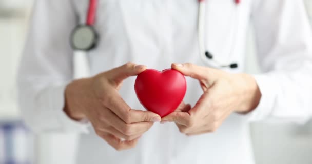 Γιατρός κρατώντας παιχνίδι κόκκινη καρδιά στο χέρι του 4k ταινία αργή κίνηση - Πλάνα, βίντεο