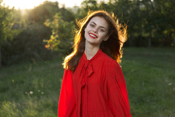 cheerful woman in a red dress in a field outdoors fresh air - Фото, зображення
