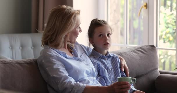 Little girl sit on couch share problems with aged granny - Filmagem, Vídeo
