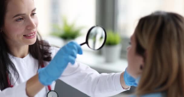 医師検査皮膚の女性の顔使用虫眼鏡4k映画スローモーション - 映像、動画