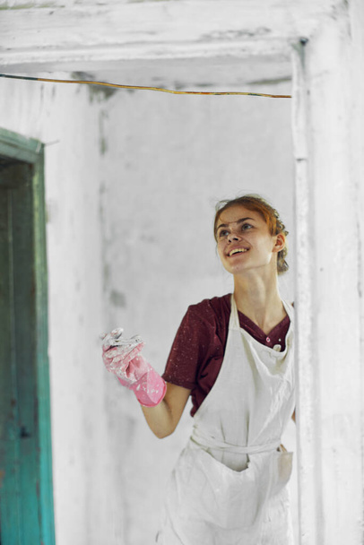 cheerful woman painter In a white apron home renovation - Foto, imagen