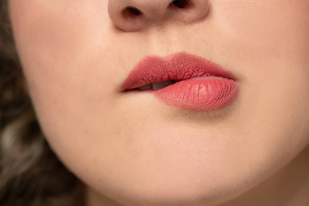 close-up van een vrouw bijten haar lip - Foto, afbeelding