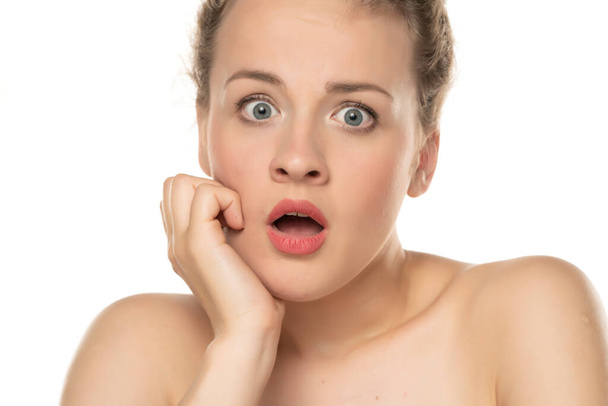 portrait of a young unpleasently surprised and shocked blonde on a white background - Photo, Image