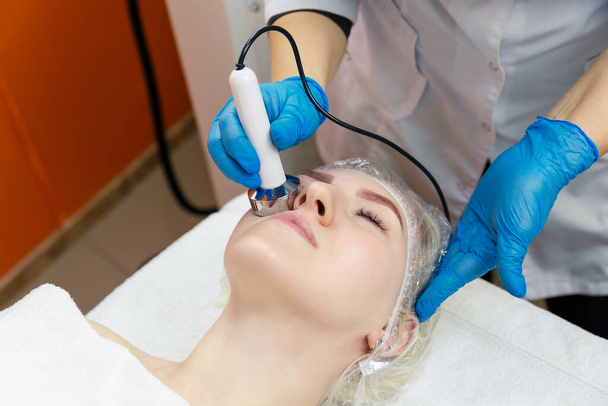 Young woman gets facial cavitation in the spa salon. - Foto, Imagen