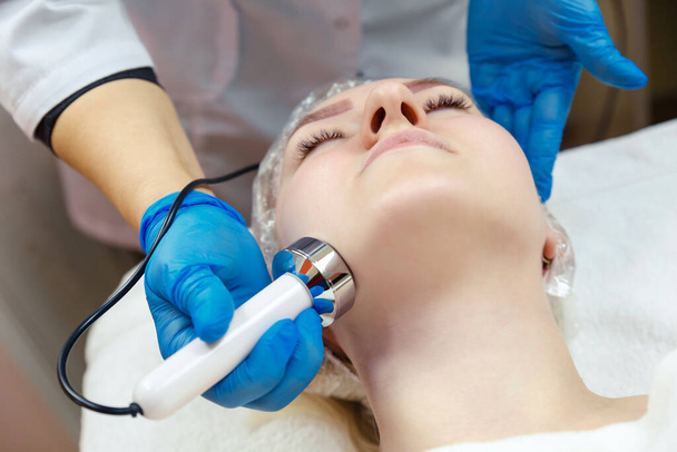 Young woman gets facial cavitation in the spa salon. - Foto, immagini