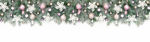 Lange banner met kerstboom slinger versierd met roze en gouden glitter ballen, witte bloemen. Achtergrond met pastel kerstballen close-up voor design template met kopieerruimte. - Foto, afbeelding