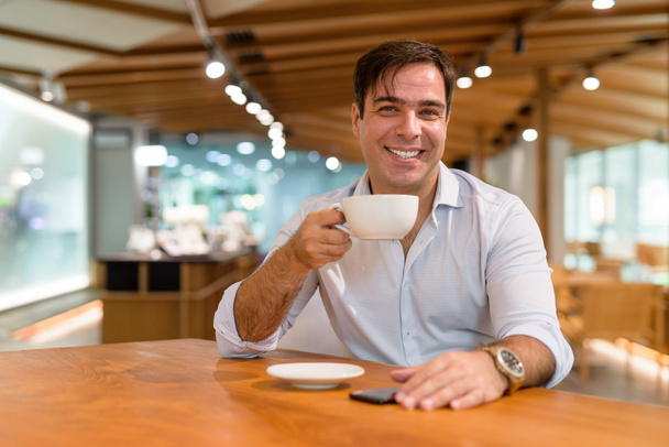 Portret perskiego biznesmena siedzącego w kawiarni - Zdjęcie, obraz
