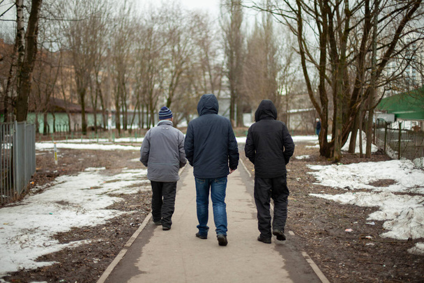 Three men walk down the road. Residents of Russia. Pensioners walk. People on the street. - Fotoğraf, Görsel