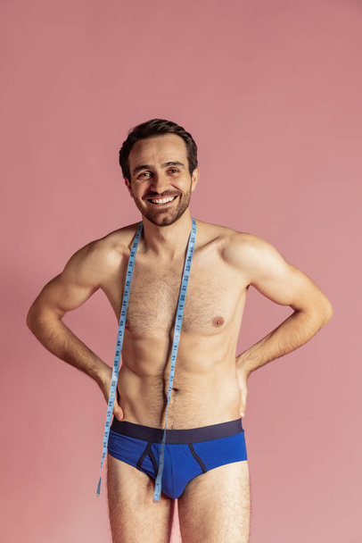 Portrait of young handsome bearded shirtless man posing and smiling isolated on pink studio background. - Foto, Bild
