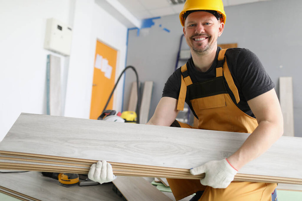 carpintero profesional llevar tablones de madera a la habitación apartamentos - Foto, Imagen