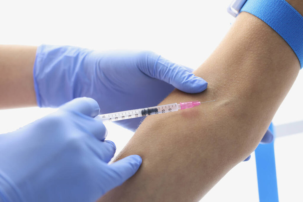 Nurse injects liquid medication in patients vein with needle - Foto, Imagen