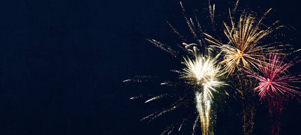 Año Nuevo silvester 2022 Año Nuevo fondo banner panorama largo fuegos artificiales fuegos artificiales en rústico azul oscuro noche cielo textura - Foto, imagen