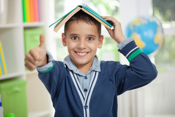 funny schoolboy with a book on head - Foto, Bild