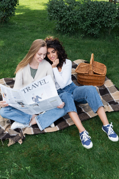 θέα υψηλής γωνίας του ευτυχισμένου λεσβιακού ζευγαριού ανάγνωση ταξιδιωτική εφημερίδα στο πάρκο  - Φωτογραφία, εικόνα