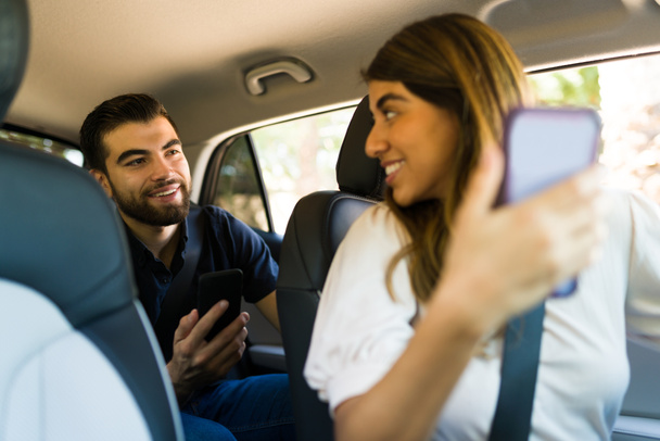 Motorista feminina feliz e passageira olhando para o GPS no aplicativo móvel no smartphone enquanto dirige para um destino - Foto, Imagem