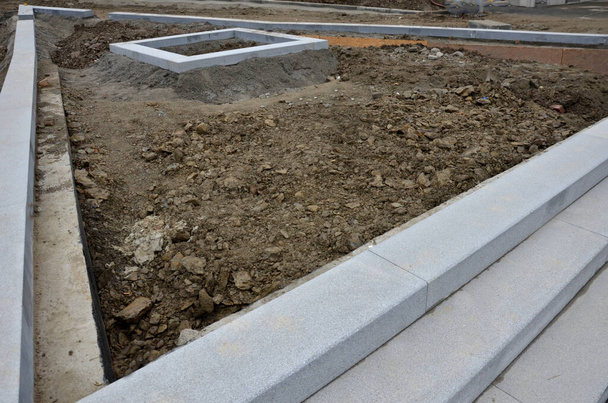 stoepranden in beton leggen. granieten stoepranden vormen de trap en de randen van de bedden. bovengrond moet nog worden ingevoerd. - Foto, afbeelding