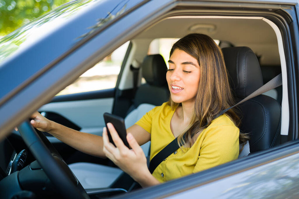 Wspaniała kobieta prowadzi samochód i rozmawia przez telefon przez telefon, podczas gdy utknęła w korku - Zdjęcie, obraz