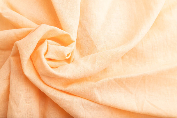 Fragment of orange linen tissue. Top view, flat lay, natural textile background and texture. wave concept, abstract, spiral form. - Foto, Bild