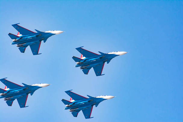 Los pilotos de aviación demuestran altas acrobacias en los cazas. Bombarderos de aviones en el cielo azul. Aviones militares en el cielo - Foto, Imagen