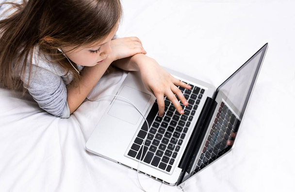Cute little girl using laptop at home. Child using gadgets to study. Online education and distance learning for kids. Home school concept. Transition to home schooling for teenagers. - Photo, Image