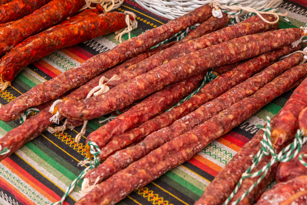 Tipikus spanyol kolbász fekszik egy falu standján az élelmiszerpiacon, hagyományos húsipari termékek - Fotó, kép