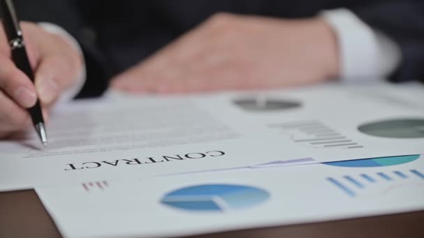 Üzletember áttekintése grafikonok és szerződések az asztalon. - Felvétel, videó