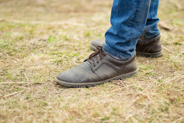 Leather boots and blue jeans. Classic fashion. Men's shoes. - Foto, afbeelding
