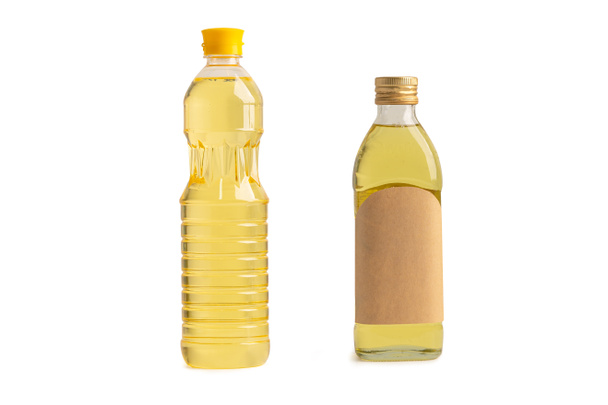 Растительное масло с оливковым маслом в разных бутылках для приготовления пищи изолированы на белом фоне с вырезкой пути. - Фото, изображение