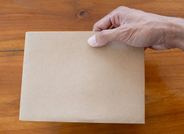 Eine Hand hält einen Papierumschlag - Foto, Bild