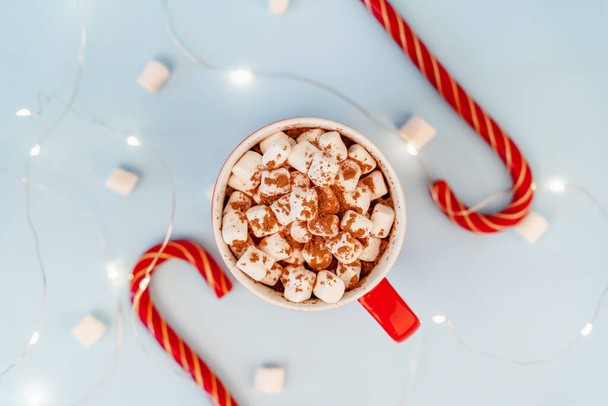 A mug of cocoa with marshmallows and a Christmas garland. A festive concept. Close up, top view - Foto, immagini