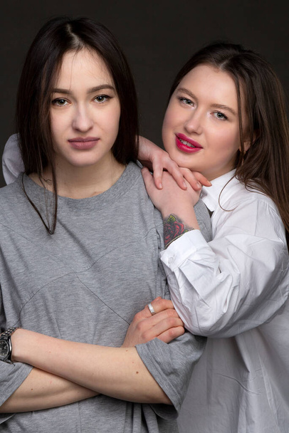 Two beautiful girls-friends on a dark background. - Fotografie, Obrázek