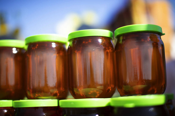 Glass jars filled with honey. Honey trade fair. - Photo, Image