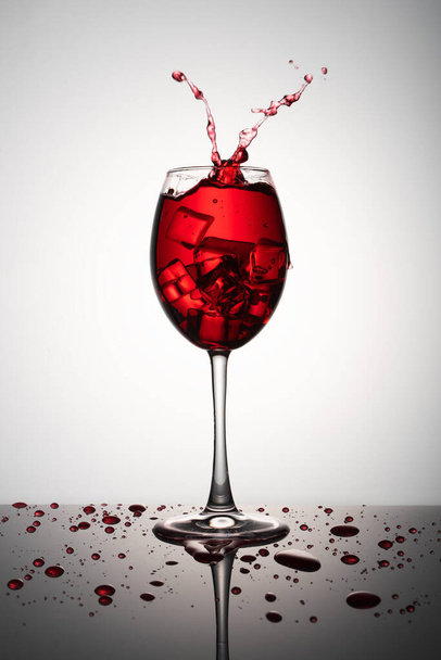 Glass of red wine with ice on a white background - Foto, immagini