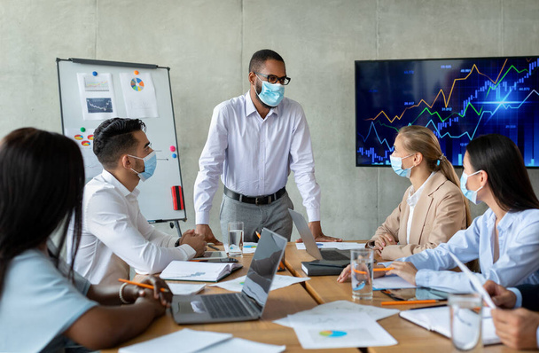 Corporate Meeting. Black Boss Wearing Face Mask Having Business Conference With Collagues - Foto, imagen