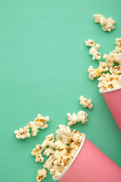 Popcorn in pink cups. Three cups of popcorn on mint background. Sweet popcorn. Top view - Foto, imagen