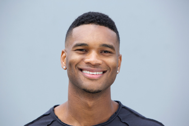 Portret van een jonge zwarte man glimlachend close-up - Foto, afbeelding