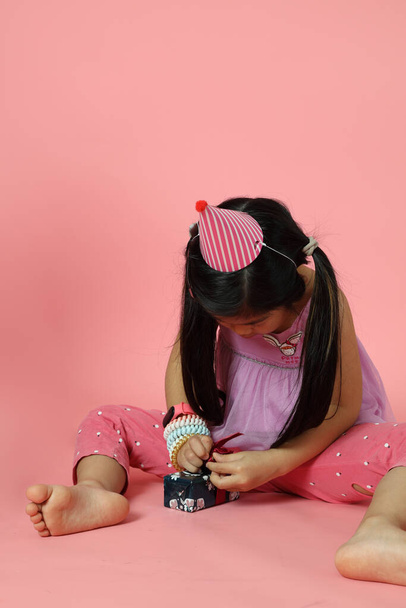 Дівчинка з Азії, яка вчиться шити, обгортає теперішню скриньку.. - Фото, зображення