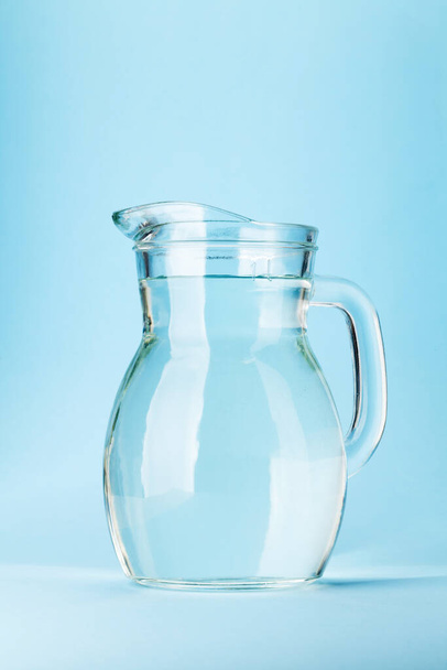 jarro de vidro com água. jarro no fundo azul - Foto, Imagem