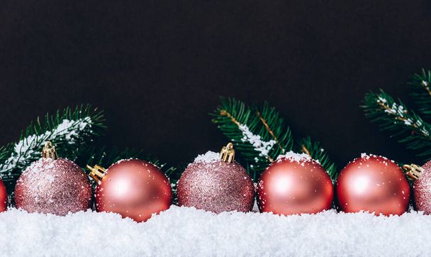 Koyu kahverengi duvarında kar taneleri olan pembe noel baloları. Zarif bir Noel dekorasyonu geçmişi var. Minimum trend tebrik kartı. Mutlu Noeller ve mutlu yıllar.. - Fotoğraf, Görsel