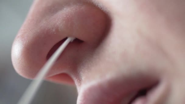 Macro filmant, une femme fait un test rapide d'écouvillonnage nasal pour covid-19 - Séquence, vidéo