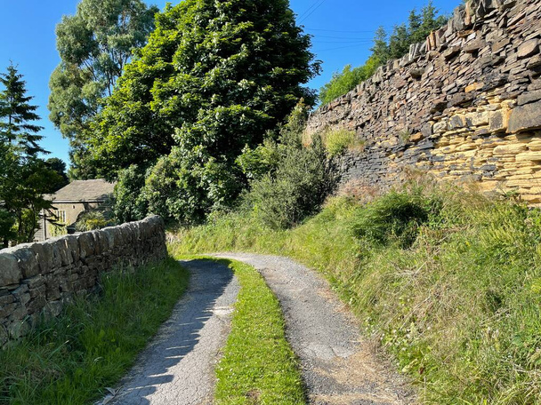 Стара колія, що веде з дороги Білі Ворота, з високими сухими кам'яними стінами, деревами і сонцем, Wainstalls, Halifax, UK - Фото, зображення