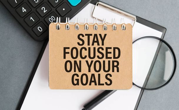 Inspirational quote - Stay focused on your goals. With text message on white paper book, pencils. - Фото, зображення