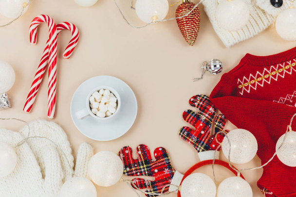 Una taza de café, suéter de punto y guirnaldas, luces led. Las mujeres moda ropa de invierno y accesorios. Año nuevo y la celebración de Navidad maqueta. Navidad naturaleza muerta - Foto, imagen