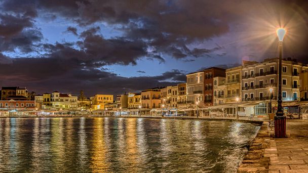 Hanian vanha venetsialainen satama yöllä värikkäitä heijastuksia hehkuvasta katuvalaisimesta, Hania, Kreeta, Kreikka, 13. lokakuuta 2021 - Valokuva, kuva